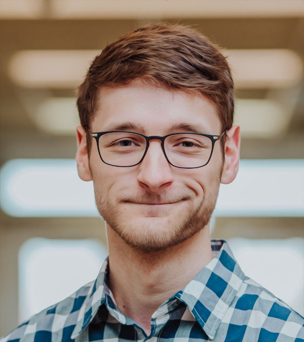 Picture of Chris wearing a blue and white checkered dress shirt.